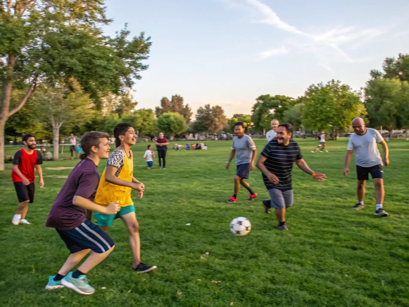 A lively image of children and adults playing soccer in a local park, showcasing community engagement in sports.